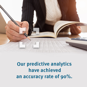 woman writing and reading a book with words "Our predictive analytics have achieved an accuracy rate of 90%"