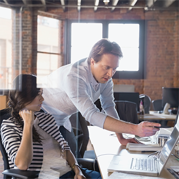 man and woman working on computer