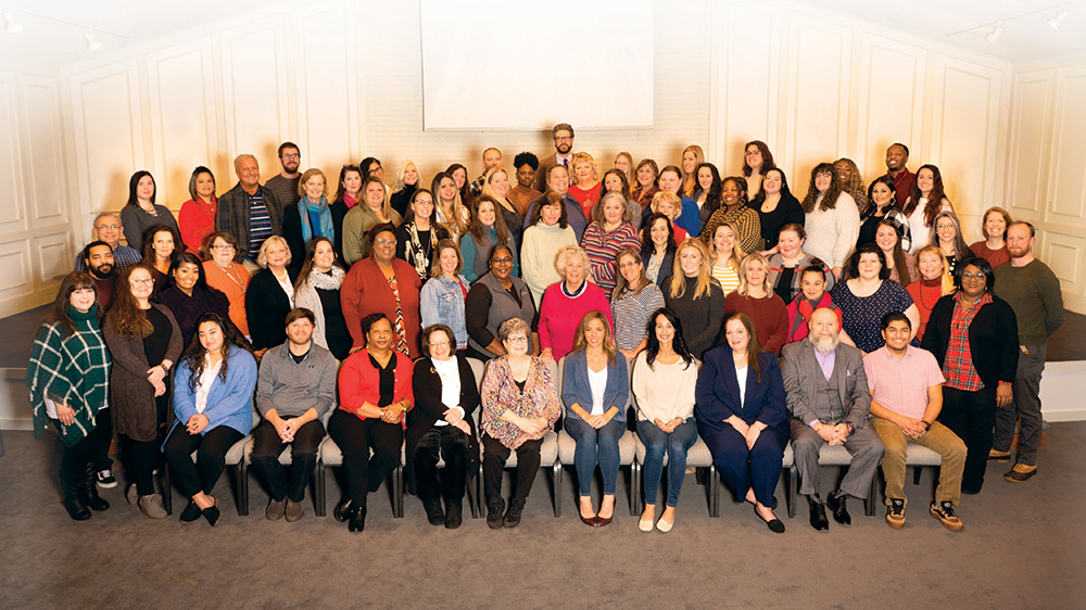 A large posed class photo of For All Seasons associates