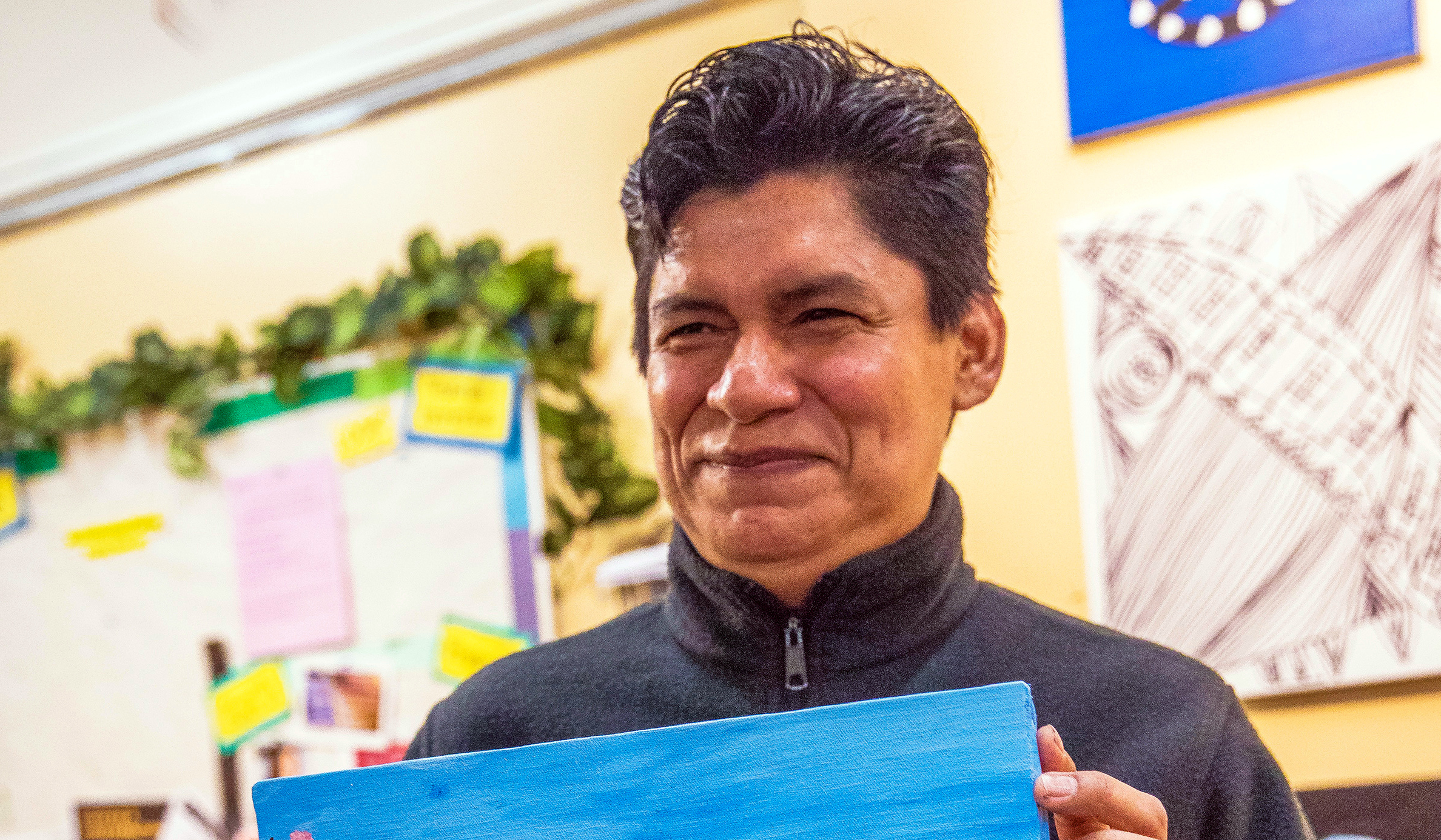 A client smiling holding artwork he made