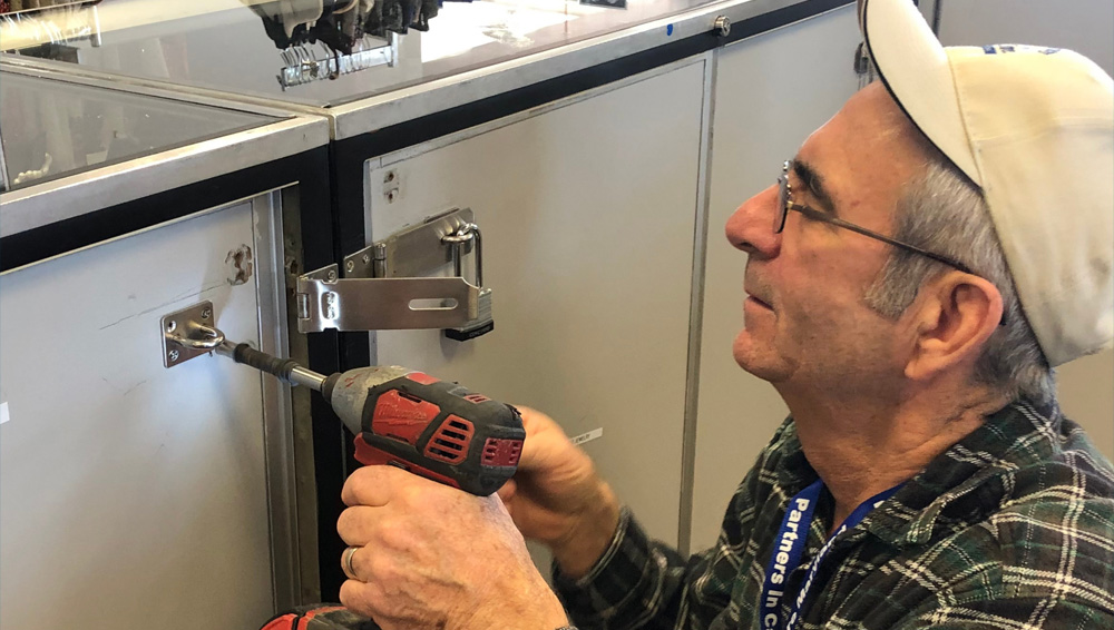 A man repairing a cabinet