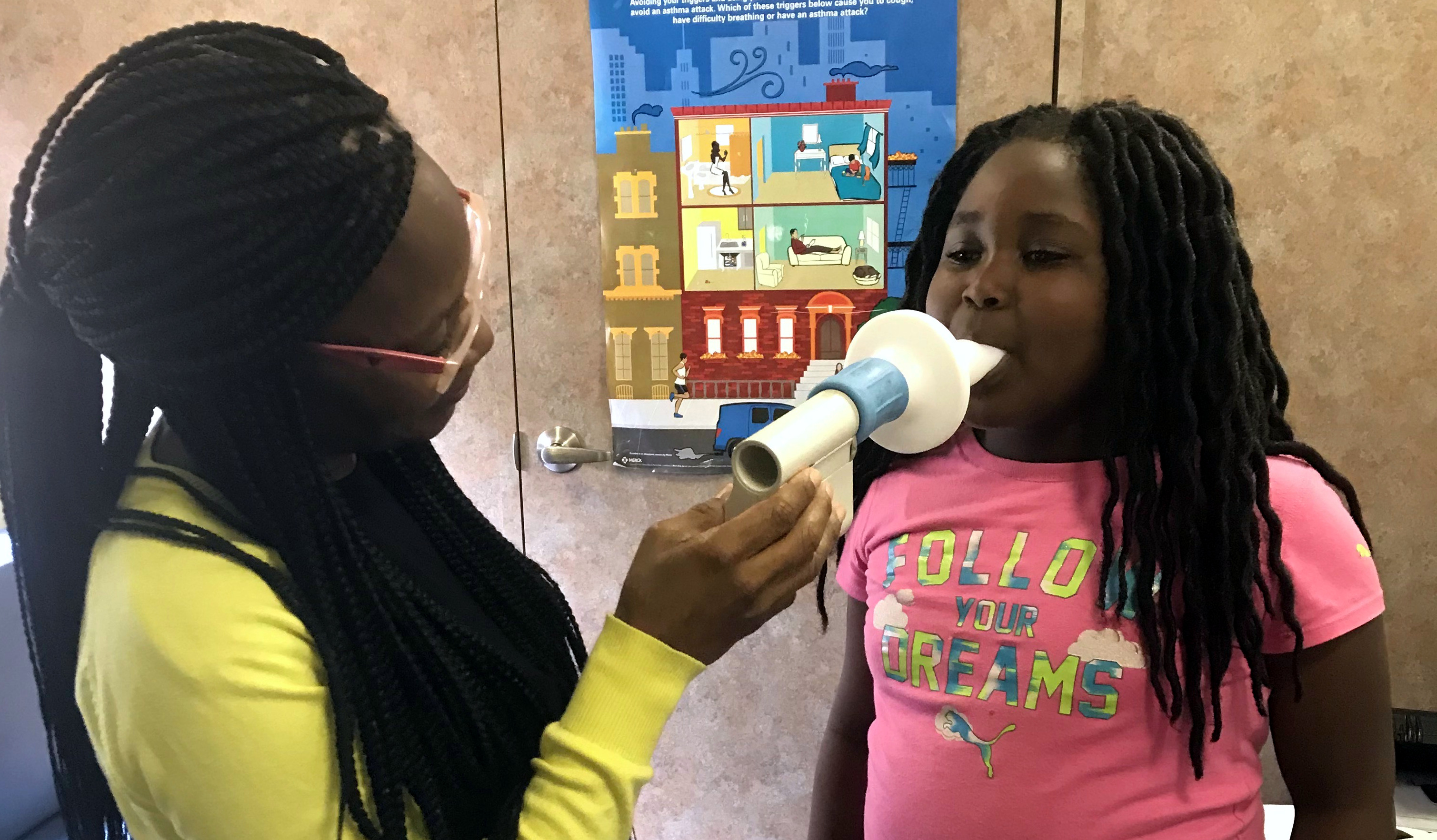 A mother holds a breathing device to her child's mouth inside the Breathmobile