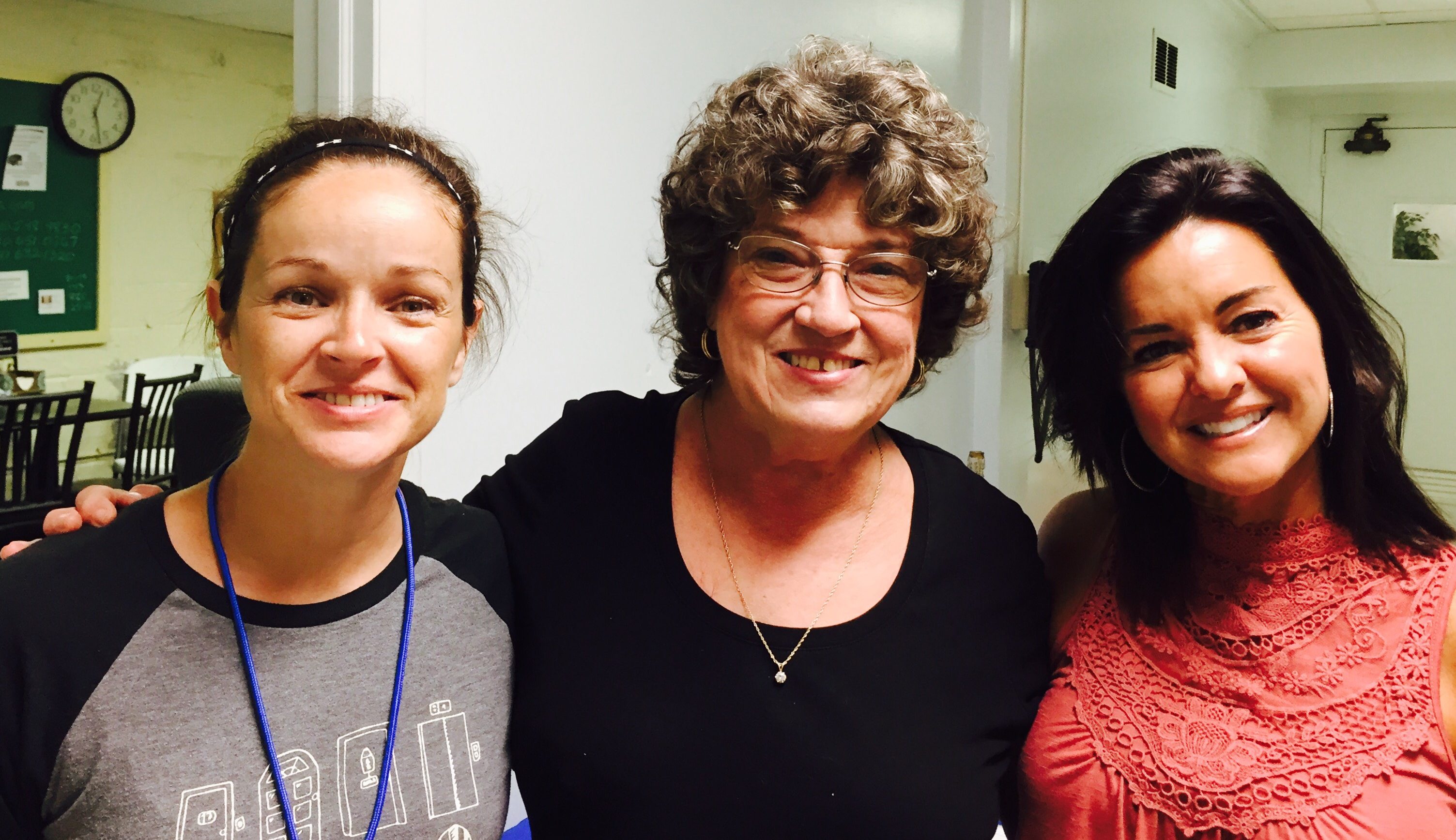 Three women smiling for the camera with arms around each other