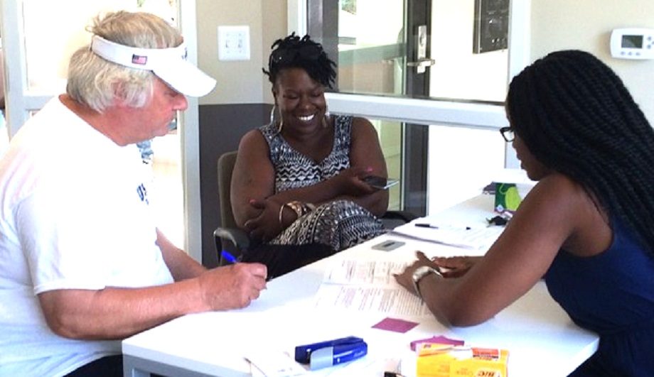 three people sitting at a white table talking