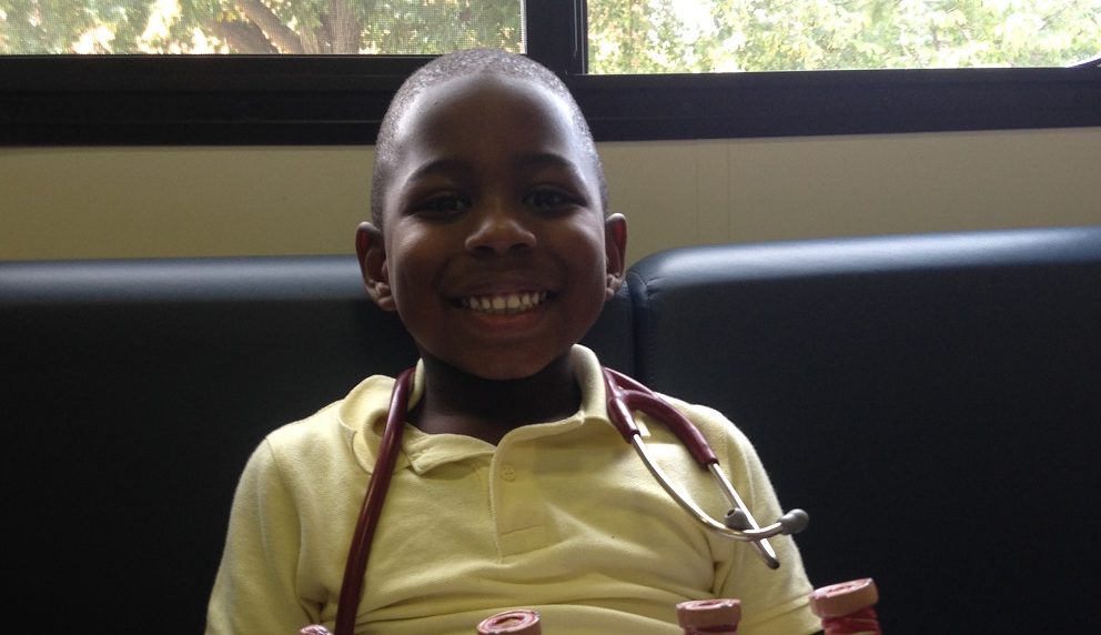 A Young boy smiling on the Breathmobile