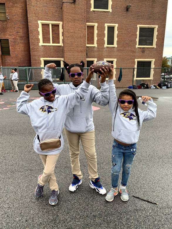 A group of three girls flexing their arms muscles