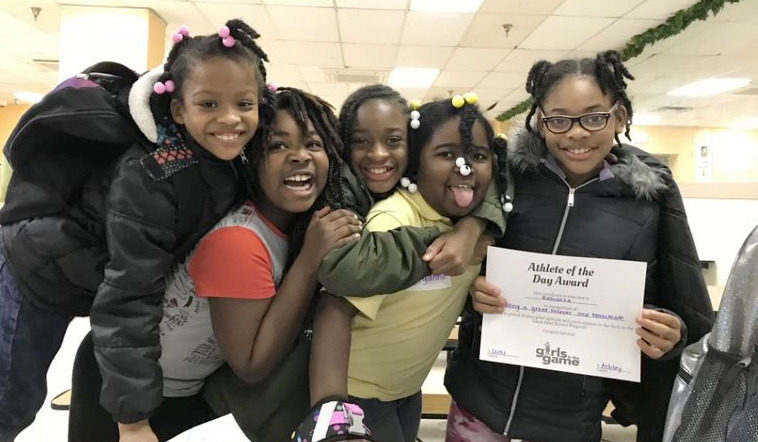 5 girls mug for the camera while one holds an award certificate