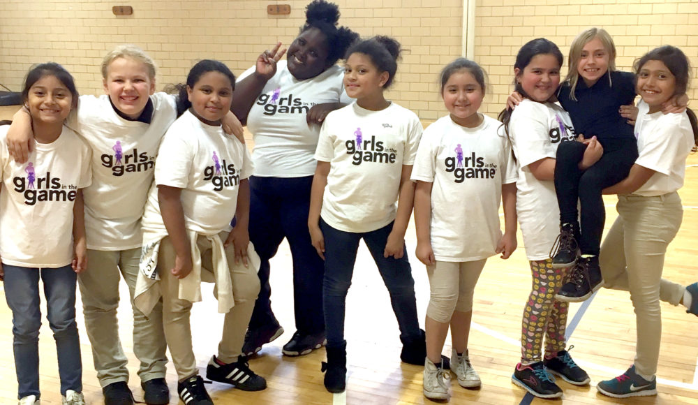 A group of girls wearing Girls in the Game T-shirts in a Gymnasium