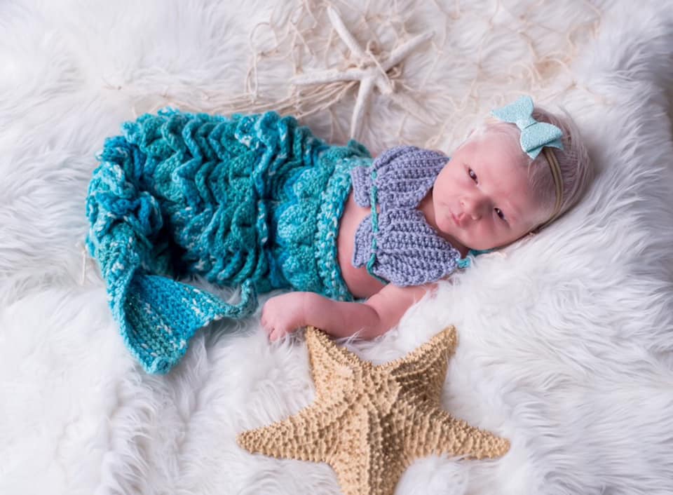 An infant in a mermaid tail outfit