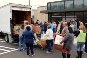 Qlarant Associates load gifts into a box truck