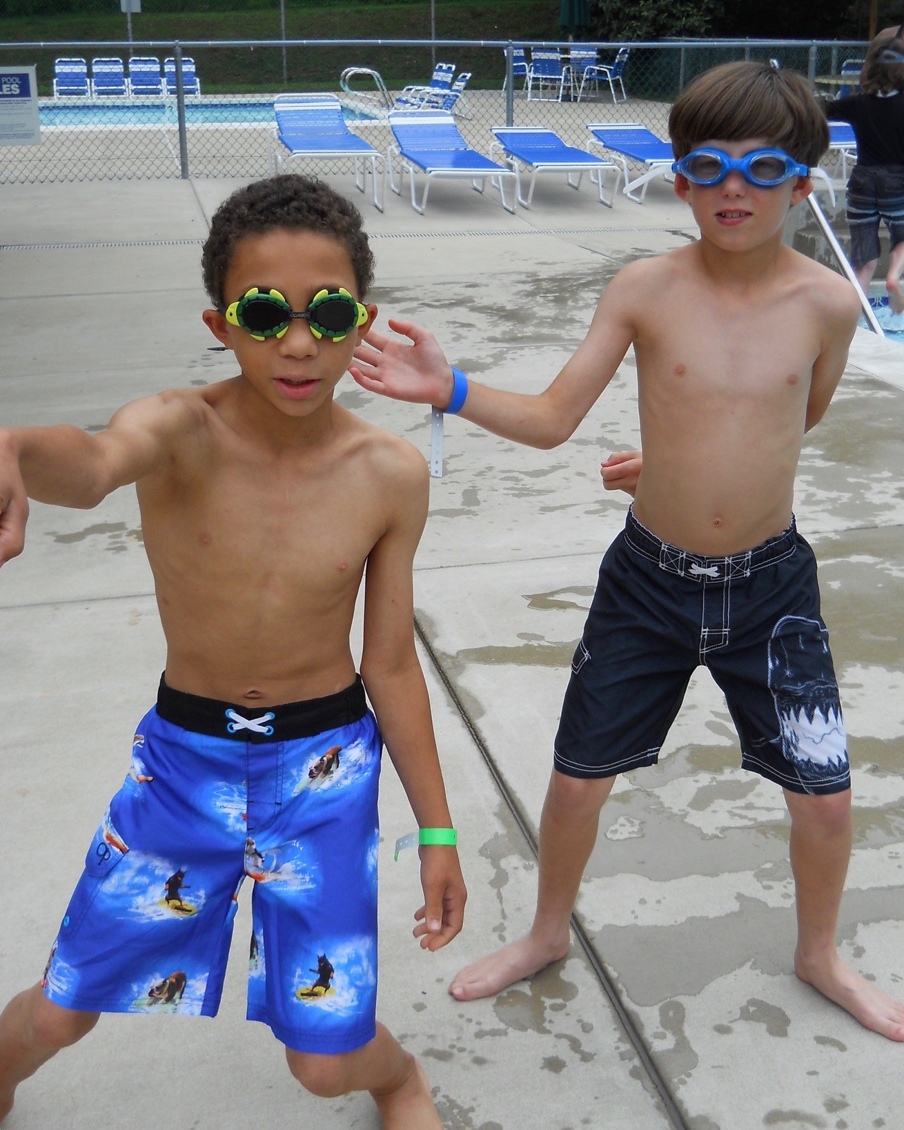 two boys dance wearing sunglasses at the pool