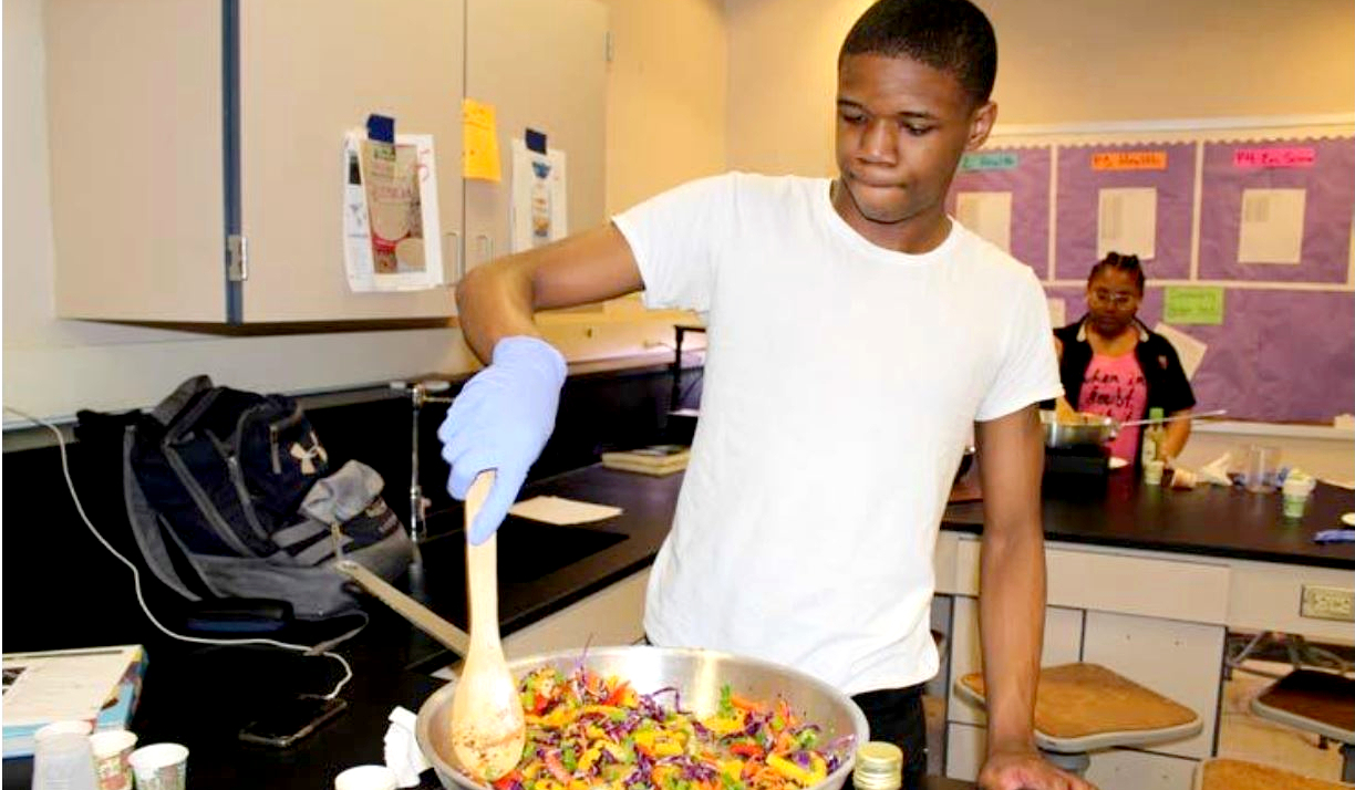 Young man cooking in a wok