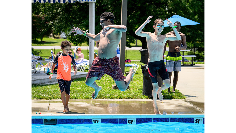 Boys jumping into a pool