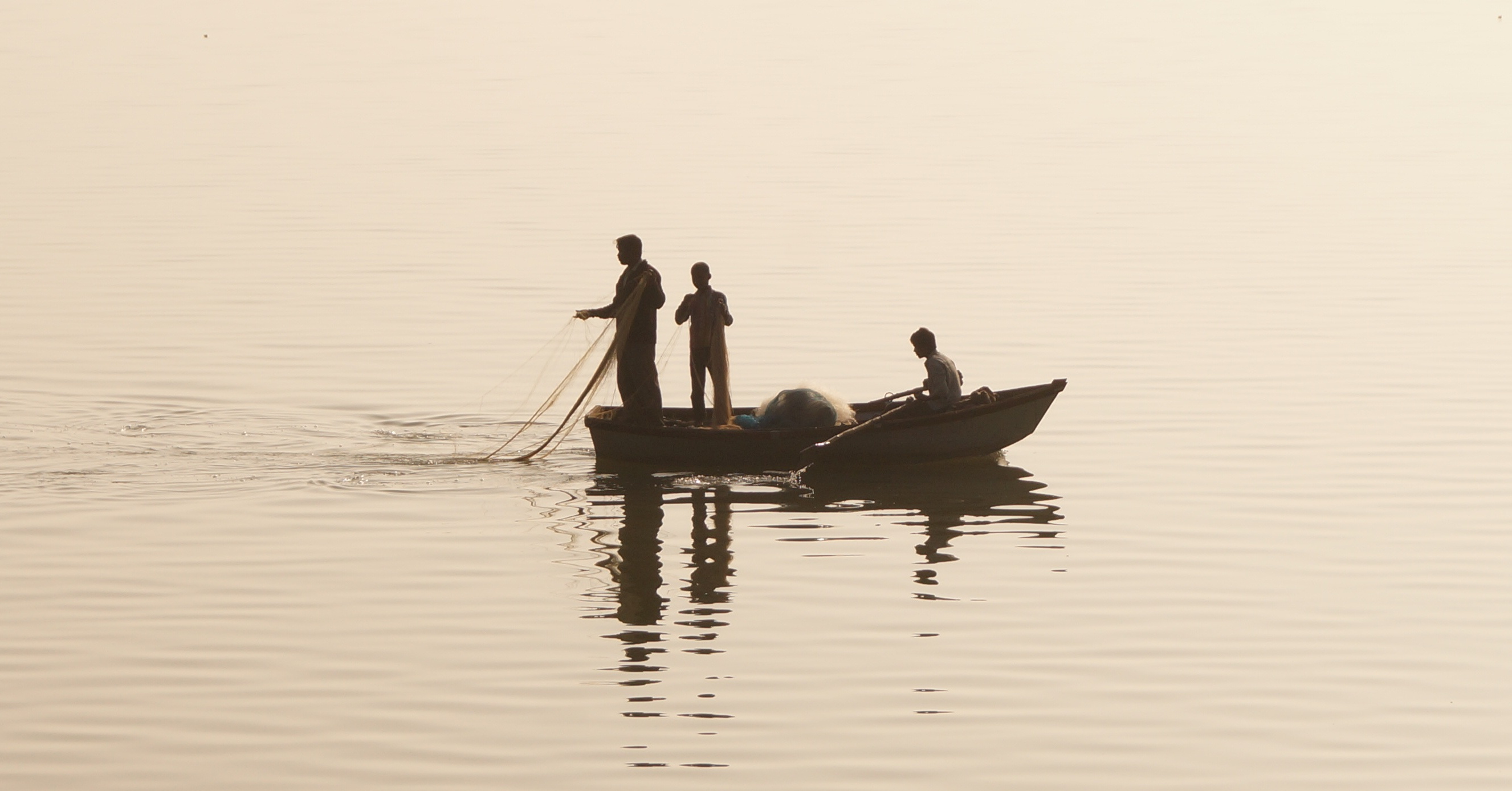 three people in a boat fishing