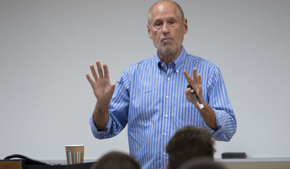 a man speaking to a group and gesturing