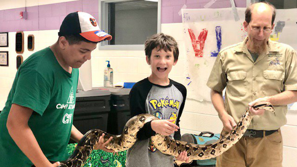 A boy holding a snake