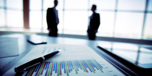 bar chart on a table with two people in silhouette standing behind