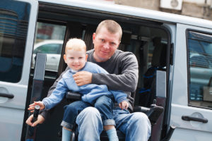 Veteran in wheelchair holding a small boy
