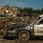 tornado damaged buildings and police car
