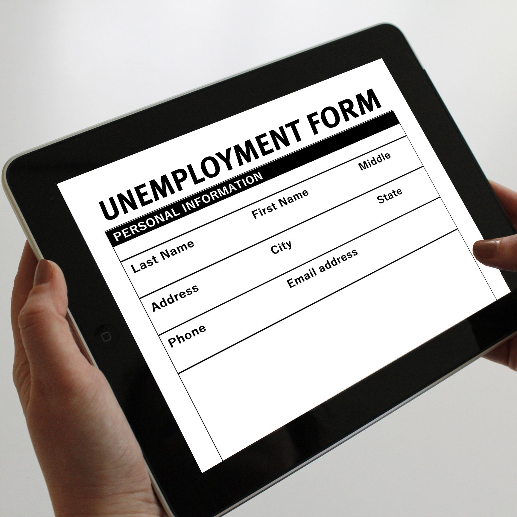 hands holding a tablet with an unemployment form on it