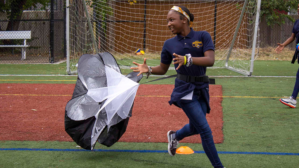 A child with a parachute on a playing field