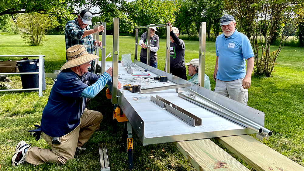 The team builds a metal wheelchair ramp