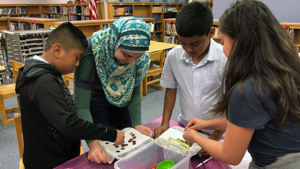 Kids in a library doing an activity with coins