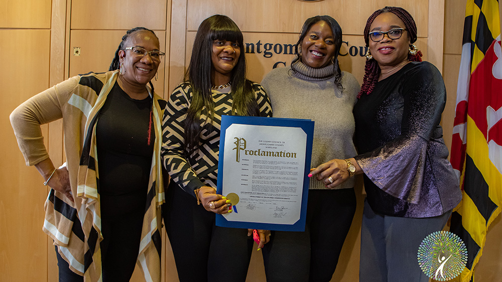 Four women holding a proclamation document at the Montgomery County Courthouse