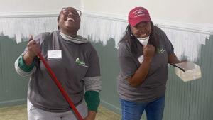 Two women laughing while painting