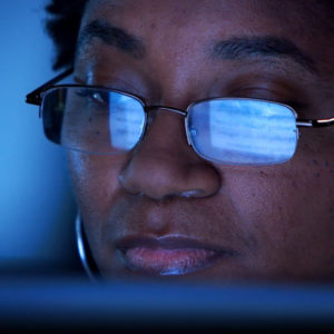 Woman in glasses reading a computer screen