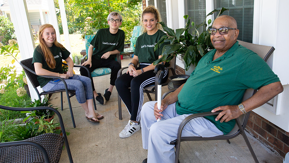Volunteers and client on a porch