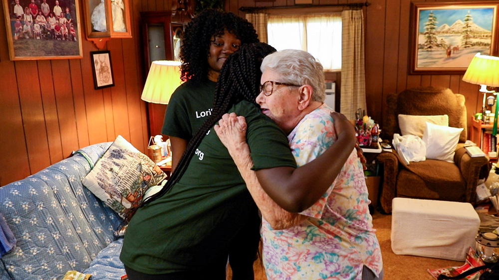 A client hugs a volunteer