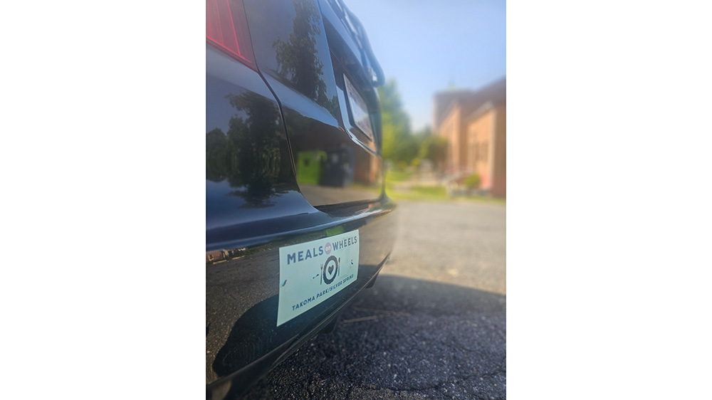 A Meals on Wheels bumper sticker on a car