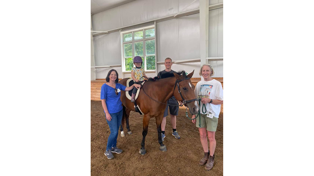 Volunteers with kids on horses