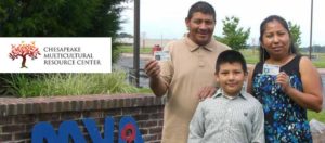 Family holding ID cards in front of DMV office
